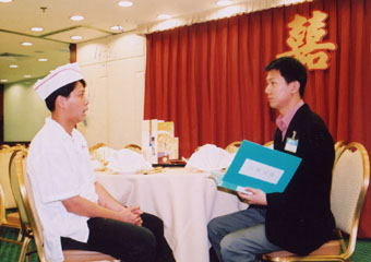 A labour  inspector collecting information on wage payment  from an employee of a catering establishment