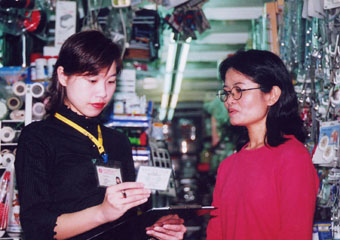 A labour inspector enforcing the Immigration Ordinance by checking an employee's proof of identity to deter illegal employment.