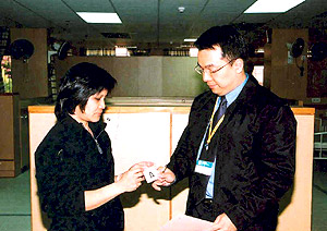 A labour inspector enforcing the Immigration Ordinance by checking an employee's proof of identity to deter illegal employment.